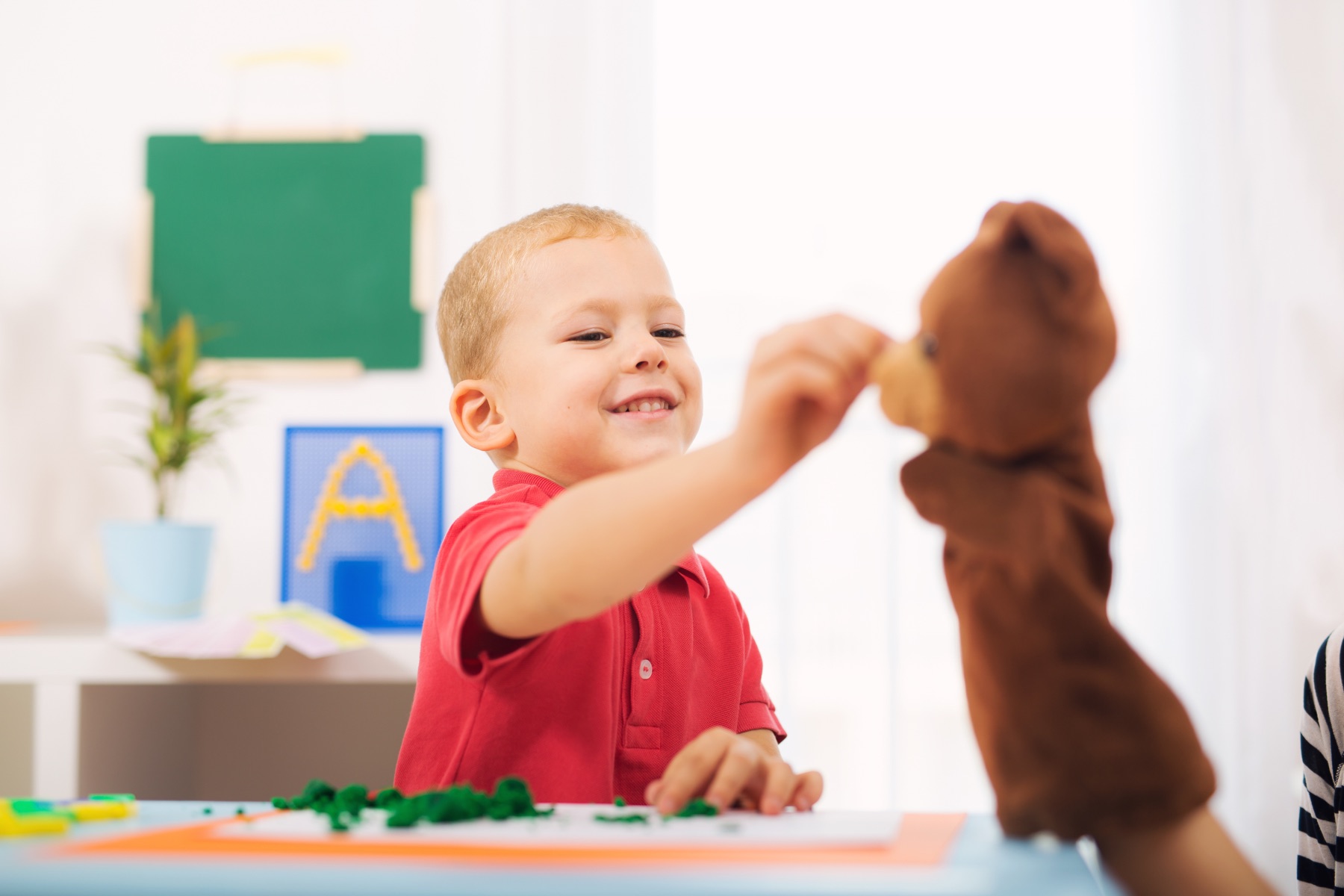 Kind spielt mit einer Handpuppe